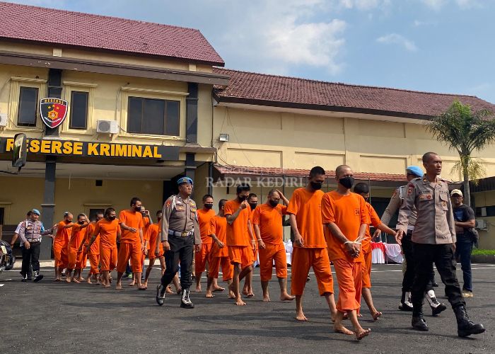 BERBARIS: Gentong bersama puluhan tersangka lainnya digelandang untuk mengikuti press release di halaman Polres Kediri Kota kemarin siang.