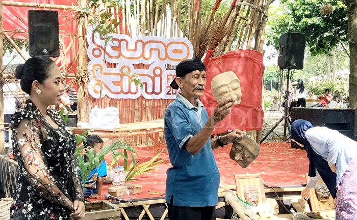 Sujito menunjukkan topeng serbuk kayu buatannya dalam workshop di area Festival Kuno-Kini pada Minggu (25/5) lalu.