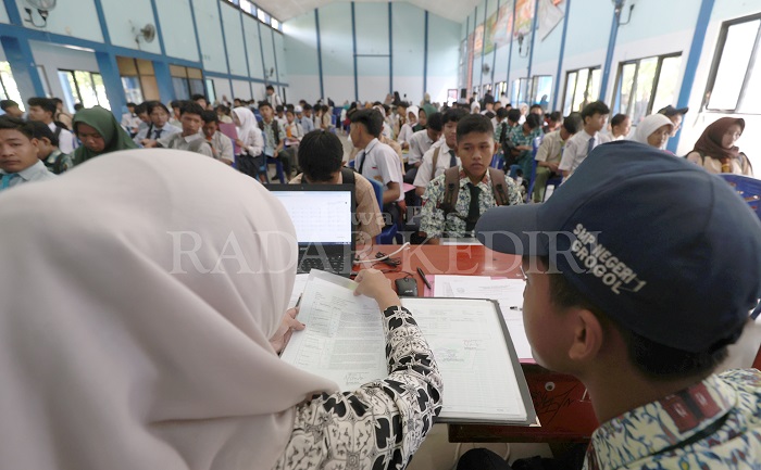 Ratusan siswa memenuhi aula SMKN 1 Kota Kediri menunggu giliran verifikasi berkas agar bisa mengambil PIN SPMB kemarin.