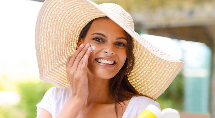 Perempuan menggunakan sunscreen