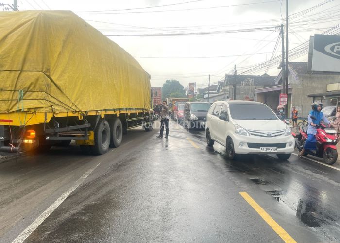 Polisi mengatur arus lalu lintas usai adu banteng di jalan raya Kediri-Tulungagung Desa Jambean, Kras, Kediri.