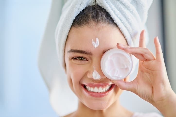 Ilustrasi seorang perempuan menggunakan day cream.