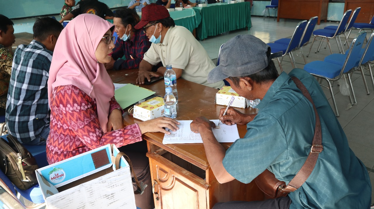 Warga menandatangai berkas agar bisa mencairkan uang ganti rugi tahannya yang terkena proyek tol Kediri-Tulungagung.