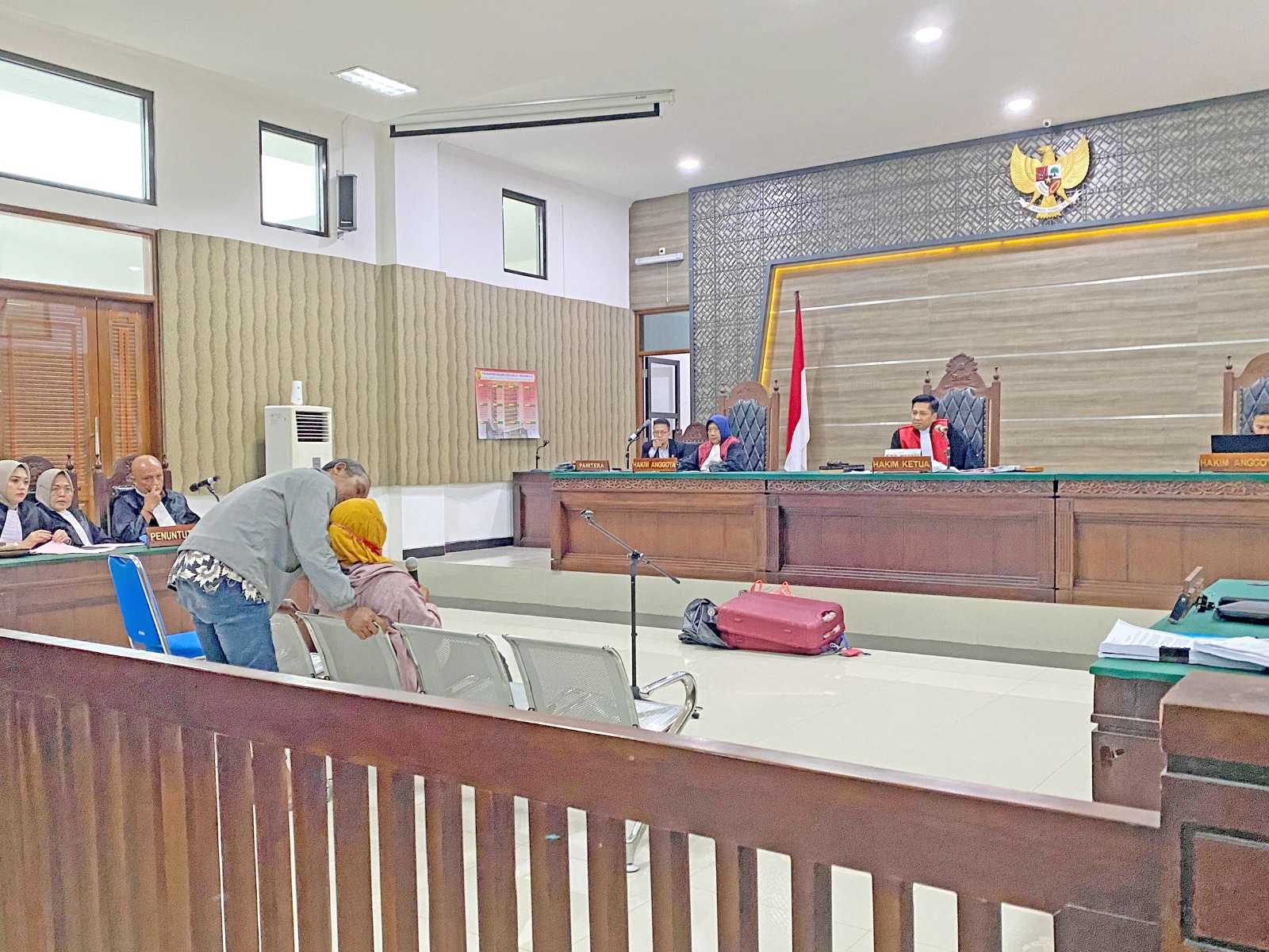 Heri Prayitno menenangkan Sulatemi, istrinya, yang kemarin menangis tersedu-sedu saat memberi keterangan tentang pembunuhan Uswatun Khasanah, putrinya, di PN Kota Kediri.