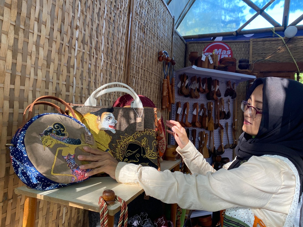 Sri Marilin dengan karya-karya yang terpajang di stan UMKM-nya di Grogol.