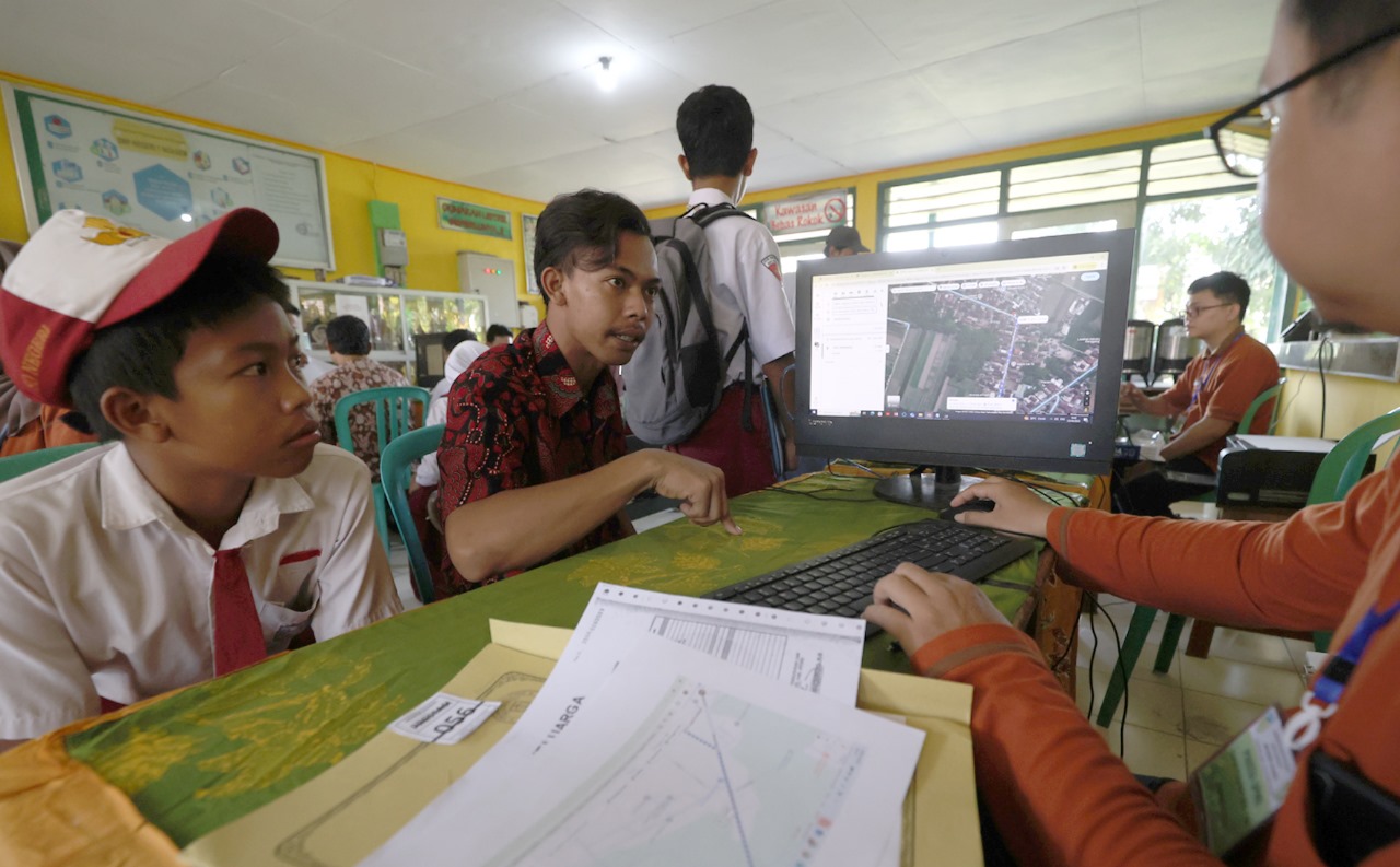 Verifikator SPMN 1 Ngasem mengecek ulang rumah siswa di Google dalam verifikasi berkas kemarin. Di hari pertama SPMB Kabupaten Kediri, jumlah pendaftar mencapai ratusan anak.
