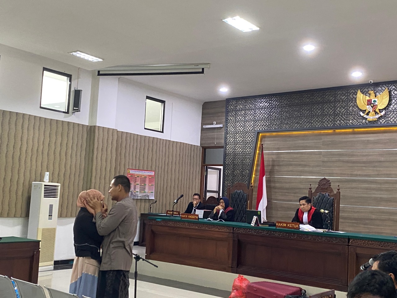 Rohmad Tri Hartanto menyeka air mata Sri Juwantini, istrinya, usai memeluk perempuan yang kemarin memberi kesaksian di depan majelis hakim PN Kota Kediri (23/6).