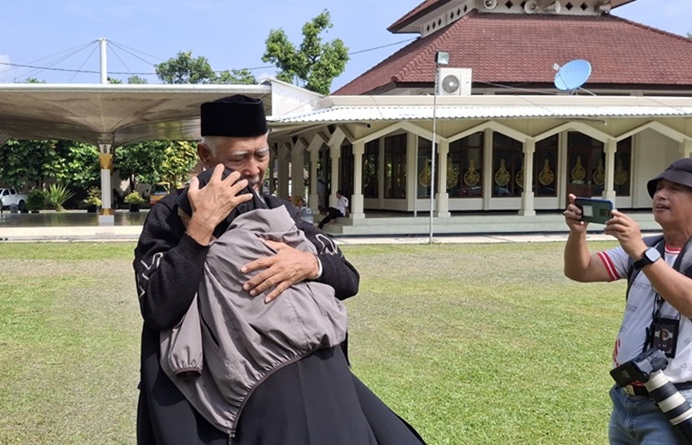 Seorang jemaah haji berpelukan dengan kerabatnya ketika tiba di Kediri (25/6) siang.