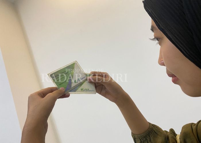 BELUM CAIR: Warga Kabupaten Kediri mengamati kartu BPJS Ketenagakerjaan.