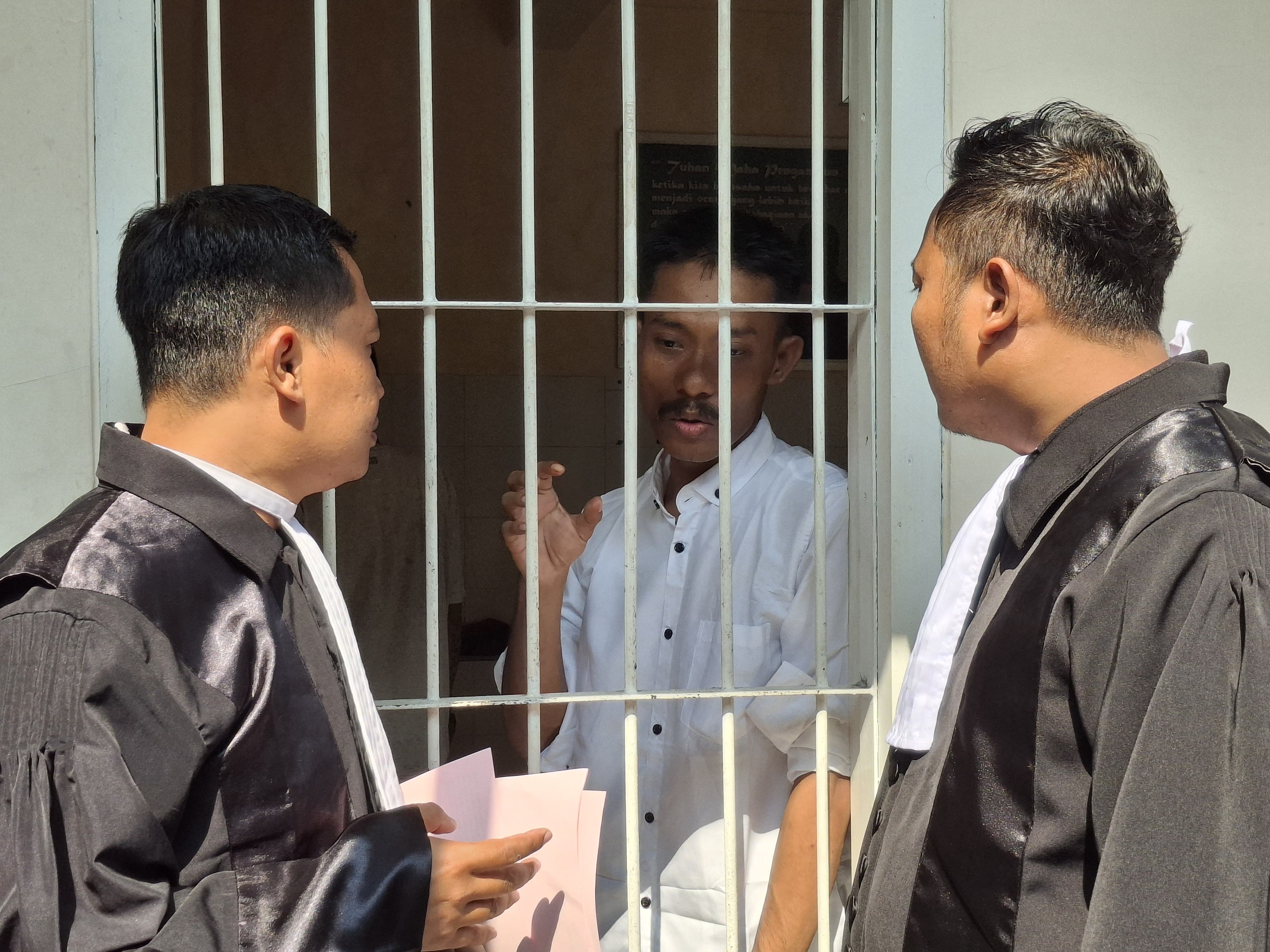SIAP SIDANG: PH Rofi saat berdiskusi dengan terdakwa Yuso.