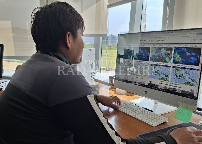 MEMANTAU: Prakirawan BMKG Bandara Dhoho Kediri mengecek kondisi cuaca di layar komputer.