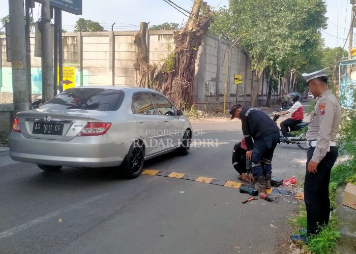 TEKAN KECELAKAAN: Petugas memasang speed bump di jalan Sisingamaraja Kelurahan Kemasan untuk menekan angka kecelakaan.