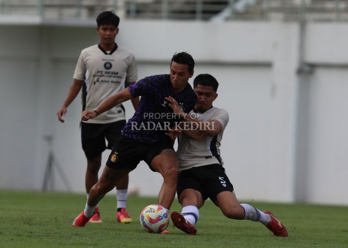 BERJIBAKU: Winger Persik Kediri Ezra Walian dihadang pemain Persiku Kudus saat uji coba di Gelora Daha Jayati kemarin.