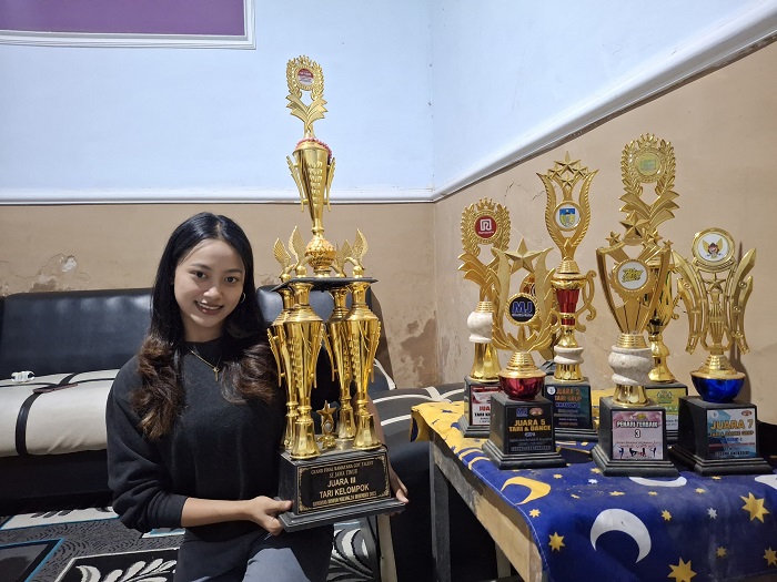 Isha Setia Putri Bersama piala-piala yang pernah diraihnya dan ketika dia tampil dalam salah satu lomba.