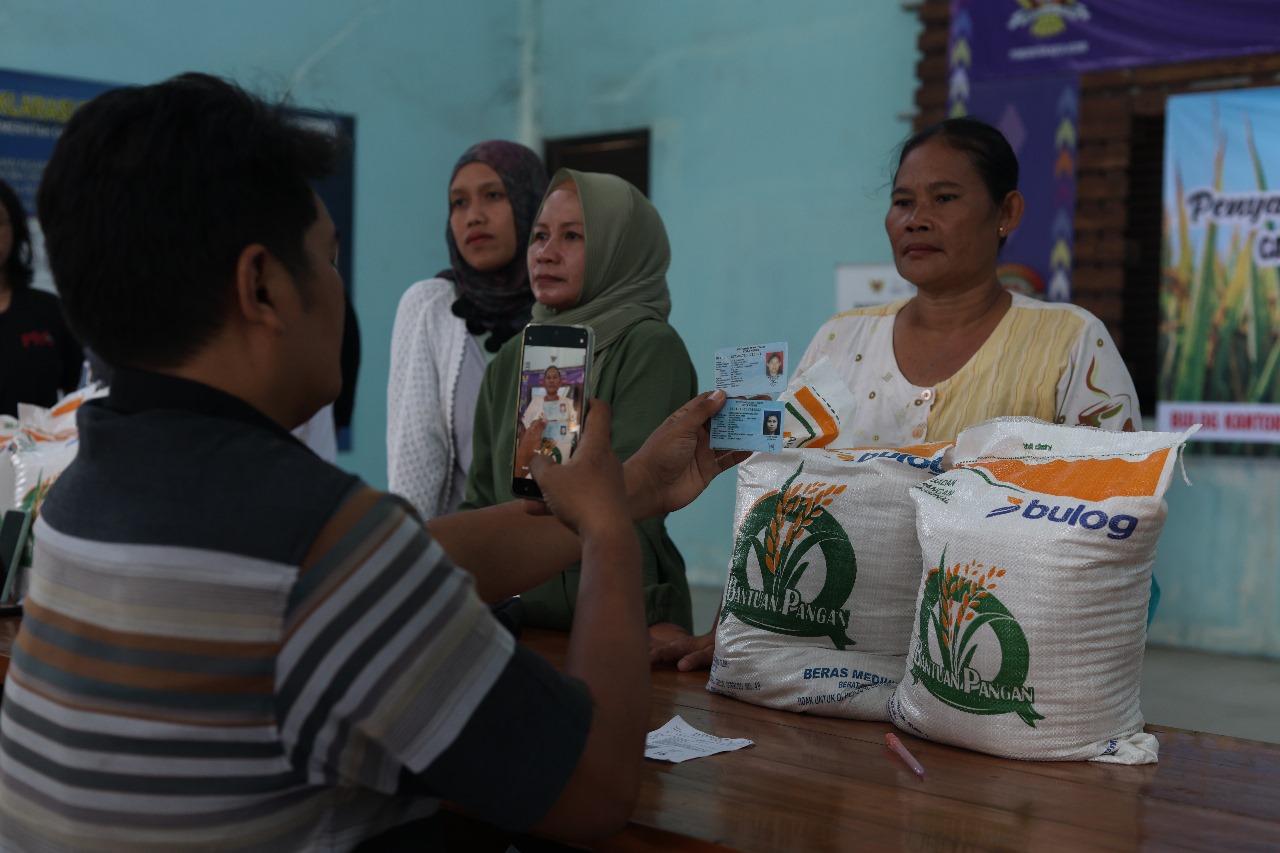 Petugas dari Perum Bulog Kediri memotret penerima beras lengkap dengan KTP mereka di Kelurahan Ngampel, Mojoroto kemarin (21/7)