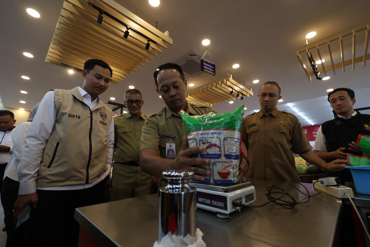 Kasatreskrim Polres Kediri Kota AKP Cipto Dwi Leksana (pakai rompi) mengecek beras premium dalam kemasan saat melakukan sidak di salah satu toko modern kemarin.