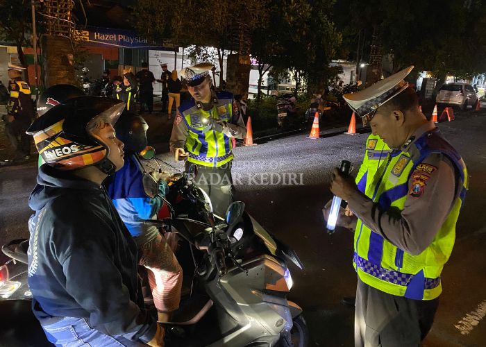PATUH SEMERU: Petugas Satlantas Polres Kediri Kota memeriksa kelengkapan dokumen dan kendaraan roda dua yang melintas di area GOR Jayabaya.