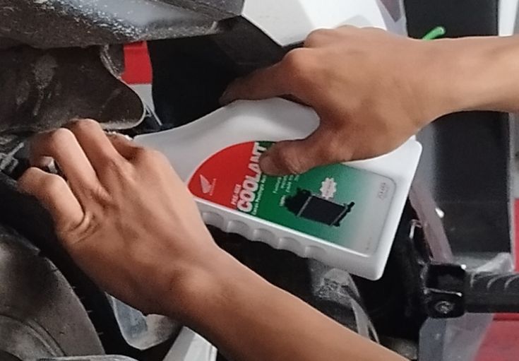 Ilustrasi mengisi air radiator pada motor.