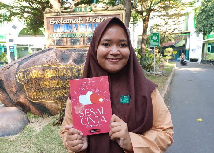 Annisa Lailly Azzahra menunjukkan buku berisi kumpulan puisi karyanya.