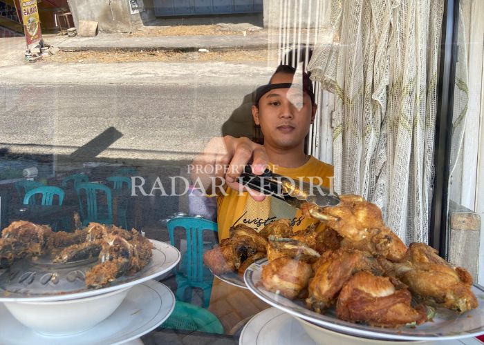 MENGELUH: Penjual makanan menyiapkan lauk untuk konsumen.