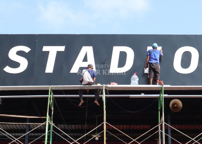 WAJAH BARU: Pekerja merampungkan pengecatan tribun VIP Stadion Brawijaya, Kota Kediri. Progres renovasi diklaim telah mencapai 70 persen.