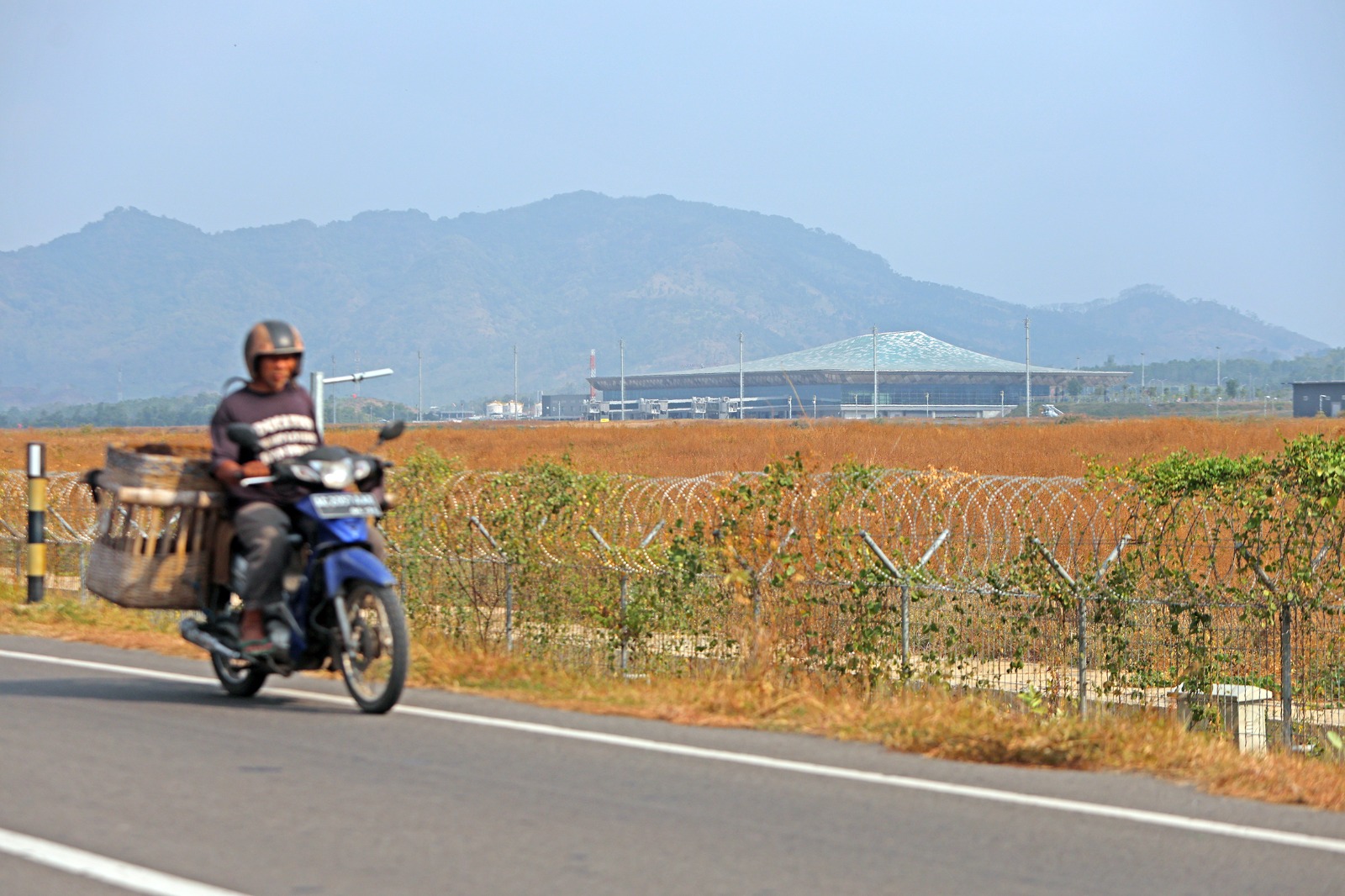 Pengendara sepeda motor melintas di depan Bandara Dhoho Kediri. Bandara yang baru berusia setahun ini akan mencetak sejarah bila rencana menjadi embarkasi dan debarkasi haji tahun depan terwujud.
