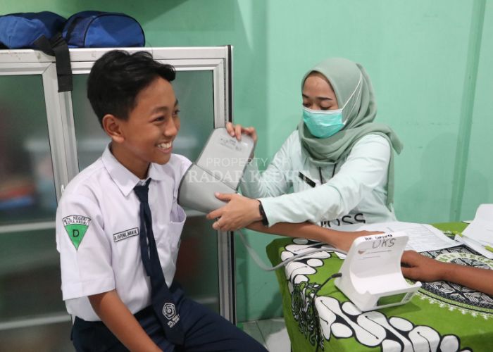 TERSENYUM LEBAR: Siswa MTsN 1 Kota Kediri antusias mengikuti Cek Kesehatan Gratis (CKG) yang digelar secara bergiliran.