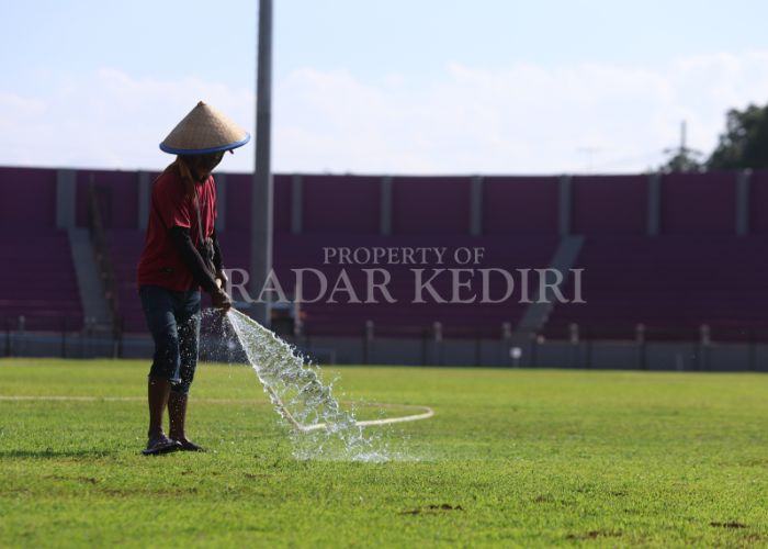 FINISHING: Pekerja menyemprotkan air ke rumput Stadion Brawijaya Kediri.