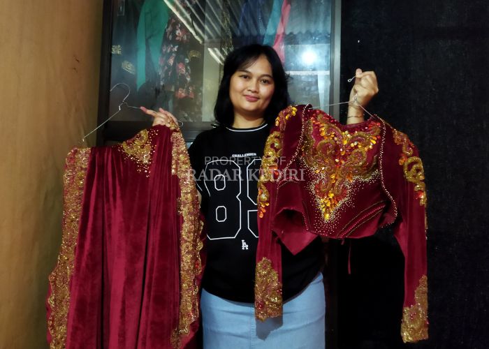 PANEN REZEKI: Nanda sedang memperlihatkan pakaian adat yang disewakannya.