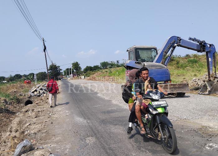MULUS: Warga melintas di jalan yang baru diperlebar menuju ke Stadion Gelora Daha Jayati (GDJ).
