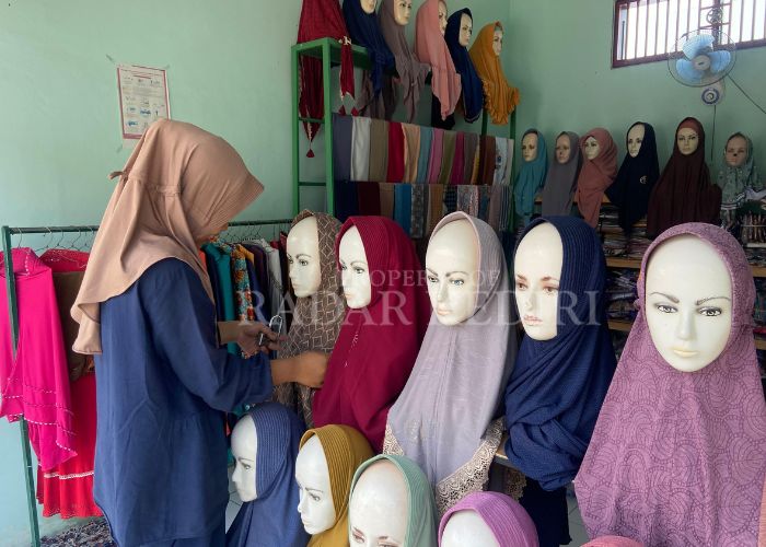 SEPI: Pedagang di Pasar Gringging menunggu pelanggan sekaligus merapikan jilbab.