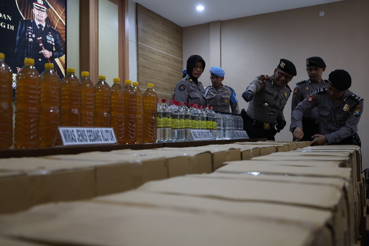 Kasat Samapta Polres Kediri AKP I Nyoman Sugita mengecek miras tak berizin yang disita dari gudang di Desa Wonorejo, Wates dalam razia Rabu (6/8) malam lalu.