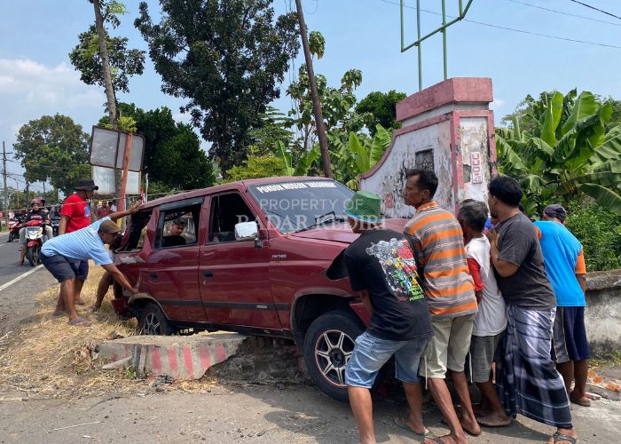HILDA NURMALA RISANI/JPRK  RINGSEK: Warga sekitar bergotong-royong mengangkat mobil Panther yang terlibat kecelakaan beruntun di jalan Kediri-Kertosono masuk Desa Janti, Papar kemarin.