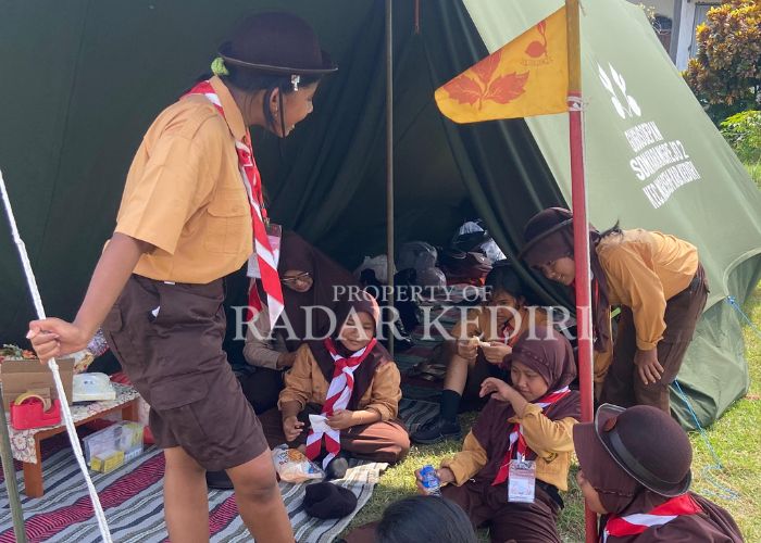 SEMANGAT: Siswa SD bercengkrama di bawah tenda. Mereka ikut memeriahkan acara kemah peringatan Hari Pramuka dan HUT RI.