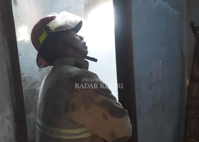 Petugas berusaha memadamkan api di rumah Darto.
