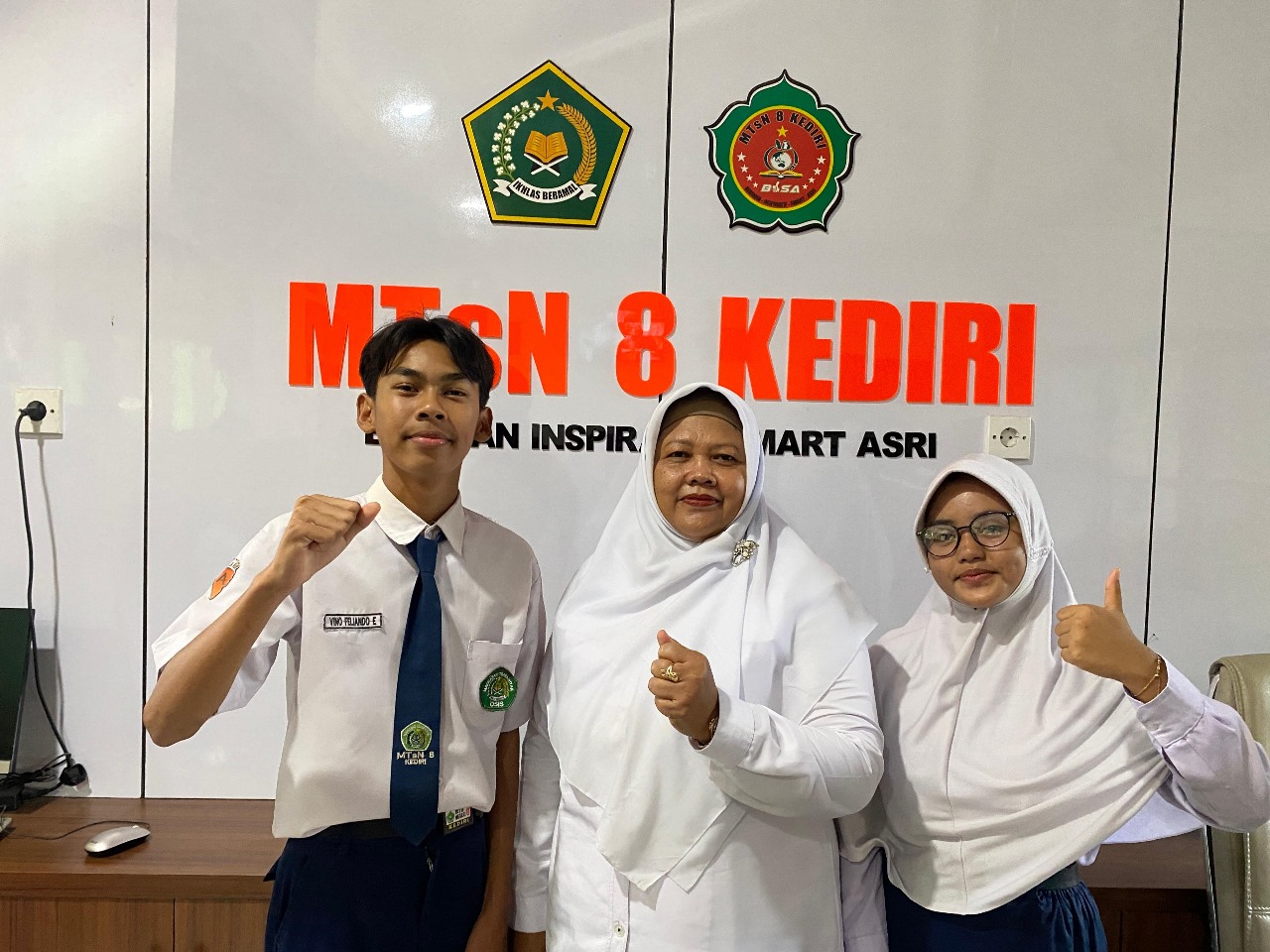 Kepala MTsN 8 Kediri diapit dua siswanya.