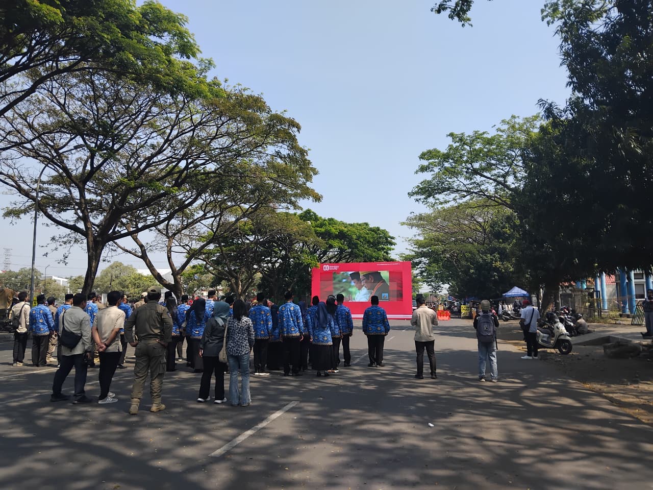 warga pengunjung CFD Gumul mengikuti upacara di Istana Negara melalui videotron.