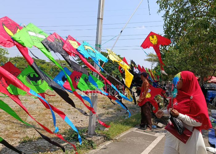 BERKAH: Darto menata layang-layang yang dijualnya di Kawasan Simpang Lima Gumul, Kediri. Dagangannya laku keras dalam beberapa hari terakhir.