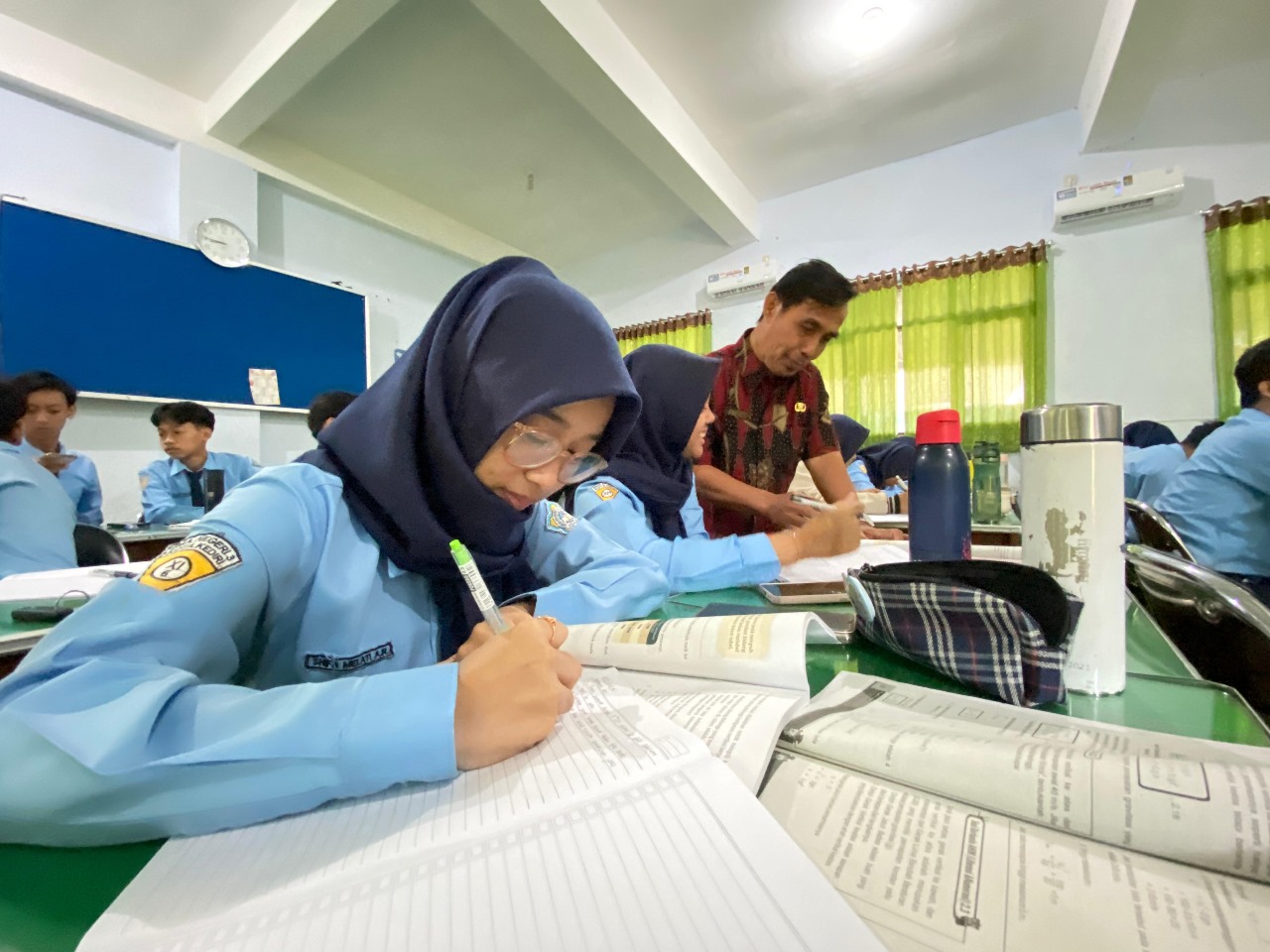 Guru SMAN 3 Kota Kediri membimbing siswa mengerjakan soal-soal fisika. Puluhan siswa dari sekolah di Kecamatan Pesantren ini siap mengikuti KKA 2025.