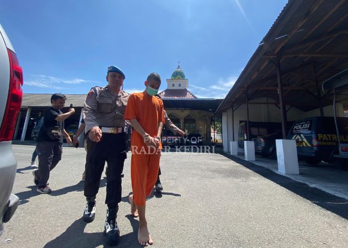 TAK BERKUTIK: Rifky digelandang petugas kepolisian untuk mengikuti press conference di Mapolsek Kediri Kota kemarin siang.