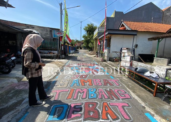 MERIAH: Warga Desa Sambirobyong menggelar mural di jalan dalam rangka peringatan HUT RI.