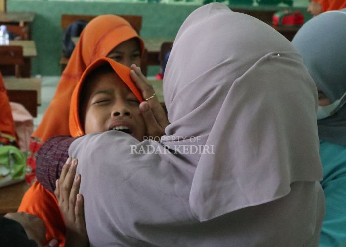 MERINGIS: Salah satu siswi SDN Bandarkidul 3 tak kuasa menahan sakit saat disuntik oleh petugas medis.