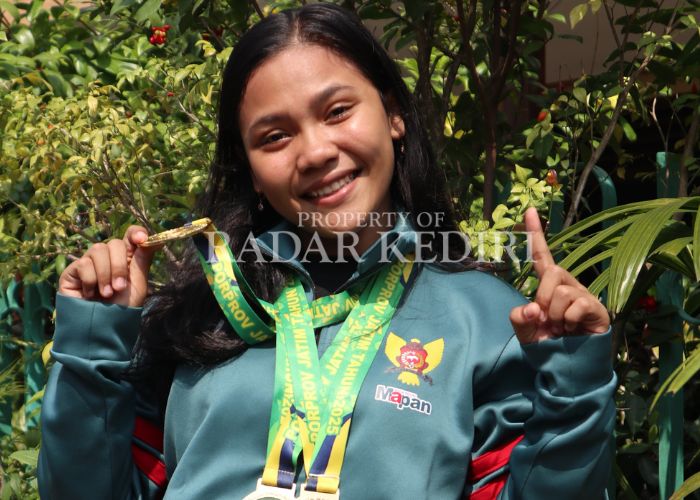 MEMBANGGAKAN: Erva menunjukkan toga medali emas yang didapat saat berlaga di Porprov Jatim 2025 cabor angkat besi.