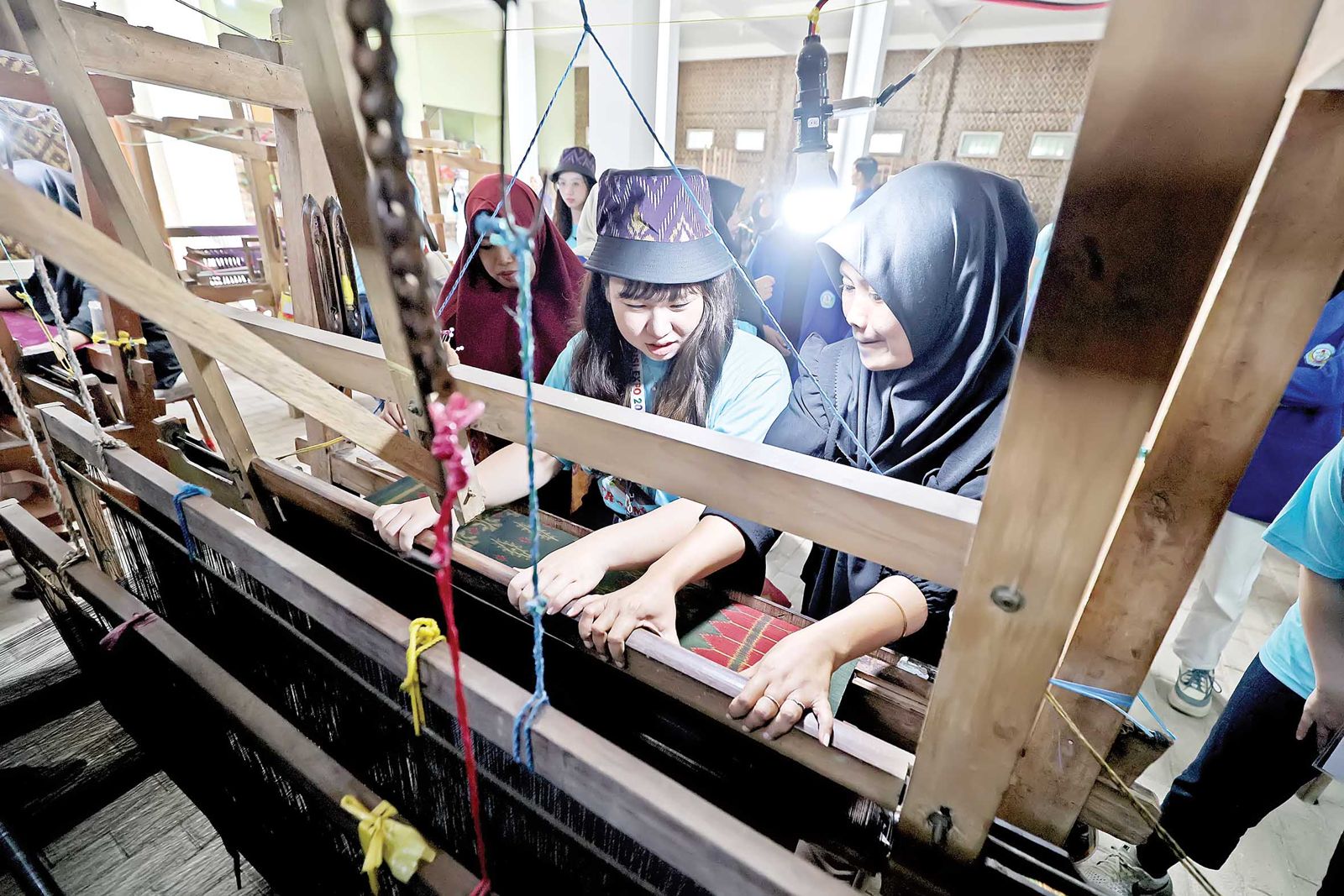 Mahasiswa National Yunlin University of Science and Technology, Taiwan, praktik menenun kain tenun ikat kemarin. Mereka kagum dengan usaha para perajin yang mempertahankan metode tradisional.