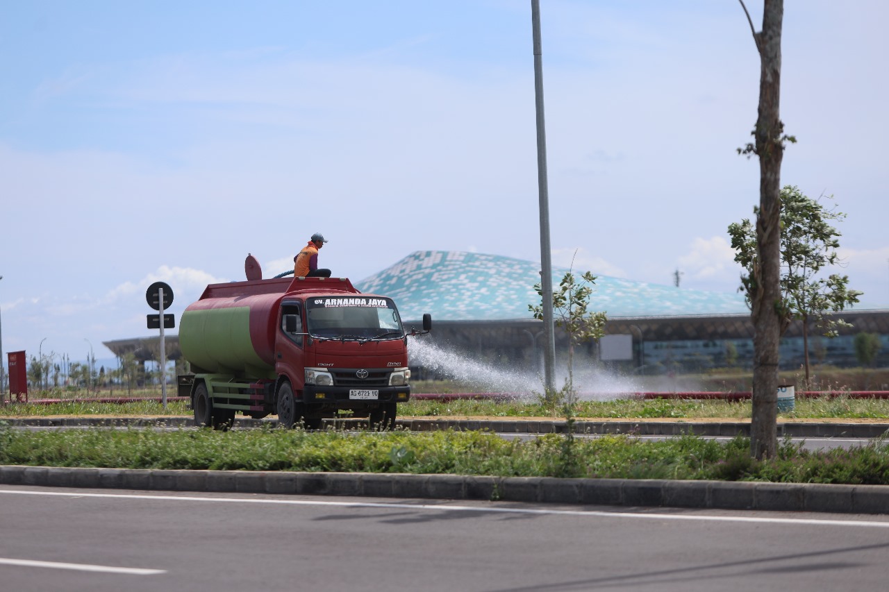 Pekerja Bandara Dhoho menyirami tanaman di sekitar bandara.