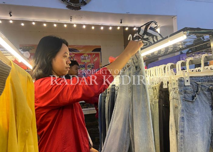 BERBURU THRIFTING: Seroang warga mencari celana di lapak pakaian bekas.