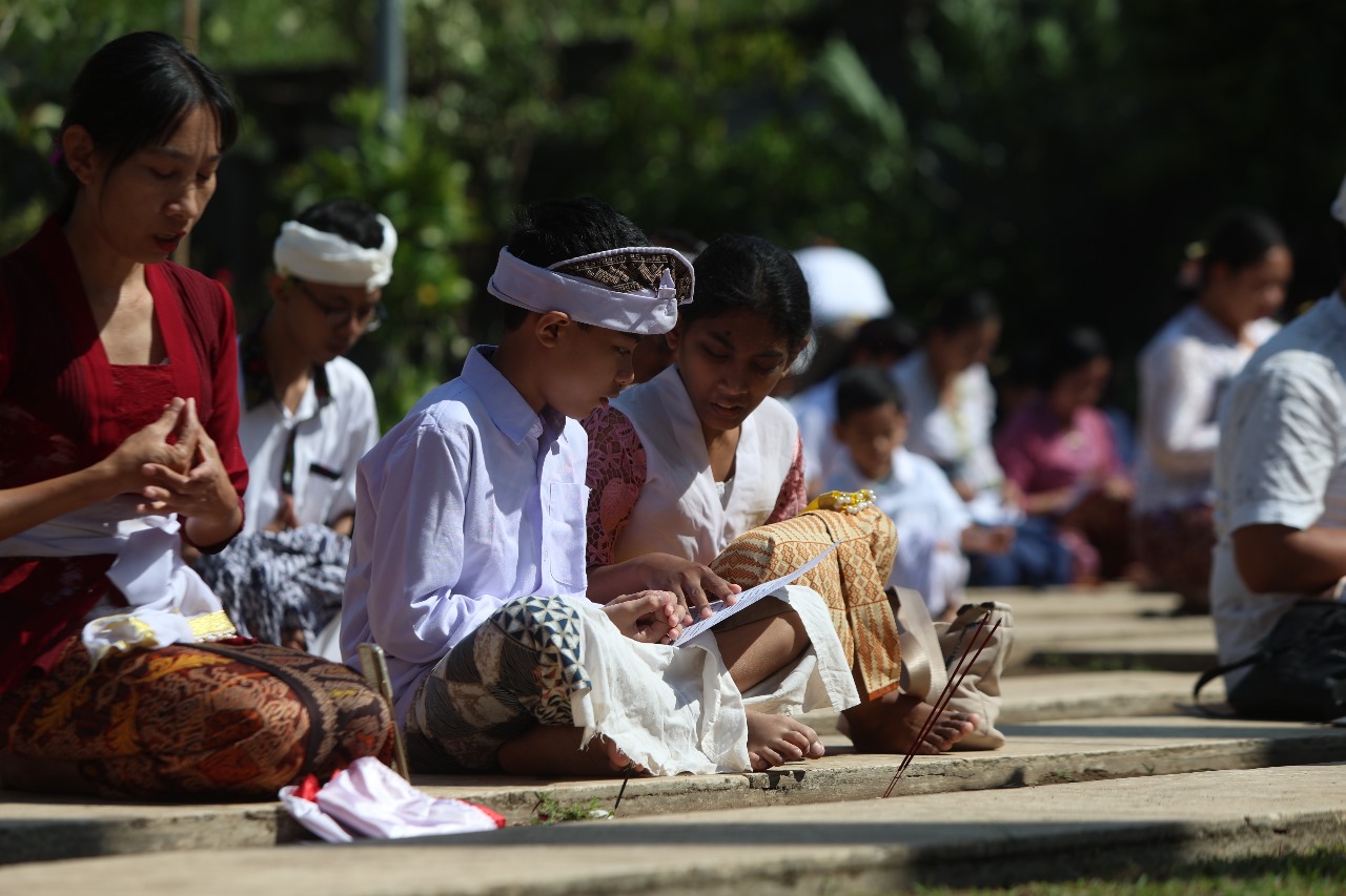 DEMI BANGSA: Umat Hindu dari semua kalangan dan usia, termasuk anak-anak, mengikuti pemanjatan doa Shanti Puja di sela sembahyang Saraswati di Pura Penataran Agung Kilisuci kemarin.