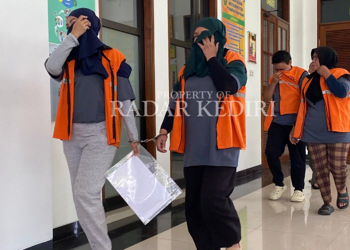 MALU: Empat terdakwa menutup wajah setelah menjalani persidangan di PN Kota Kediri.