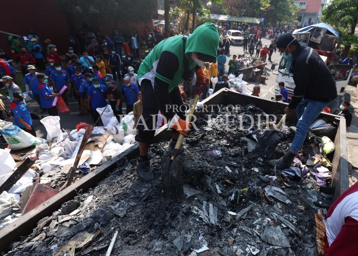KERJA BAKTI: Warga angkut sampah akibat kerusuhan di Pemkab Kediri.