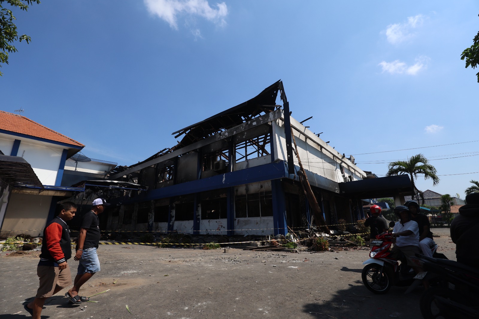 LUDES: Warga melintas di depan gedung DPRD Kota Kediri yang hangus terbakar.